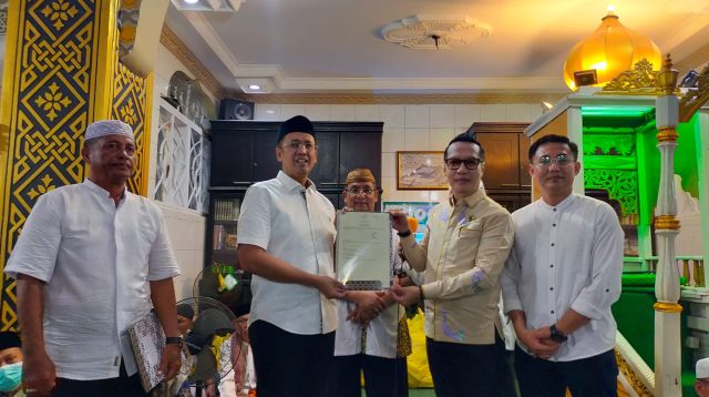Kepala Seksi (Kasi) Penetapan Hak dan Pendaftaran BPN Kota Palu Dr. Syariatudin, S.SiT, M.AP, secara langsung menyerahkan sertifikat wakaf Masjid Jami Kampung Baru, Kota Palu, kepada pengurus yang diwakili oleh Hidayat Pakamundi (Ketua Badan Pengurus Masjid Jami Kampung Baru/Anggota DPRD Prov.Sulteng), bertempat di Masjid Jami Kampung Baru, Minggu (6/4/2025) malam. FOTO: Mohammad Rizal/Filesulawesi.com