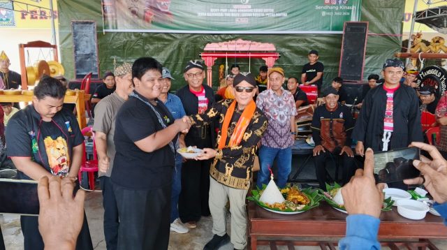 Ketua KKJST Sulteng, Sumarno, SE, secara simbolis memotong nasi tumpeng dalam semarak HUT Ke-3 Padepokan Sendhang Kinasih. FOTO: Mohammad Rizal/Filesulawesi.com