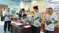Ketua PGRI Kota Palu, Eddy Siswanto, menandatangani nota kesepakatan sebagai ketua terpilih periode 2025-2030. FOTO: Mohammad Rizal/Filesulawesi.com
