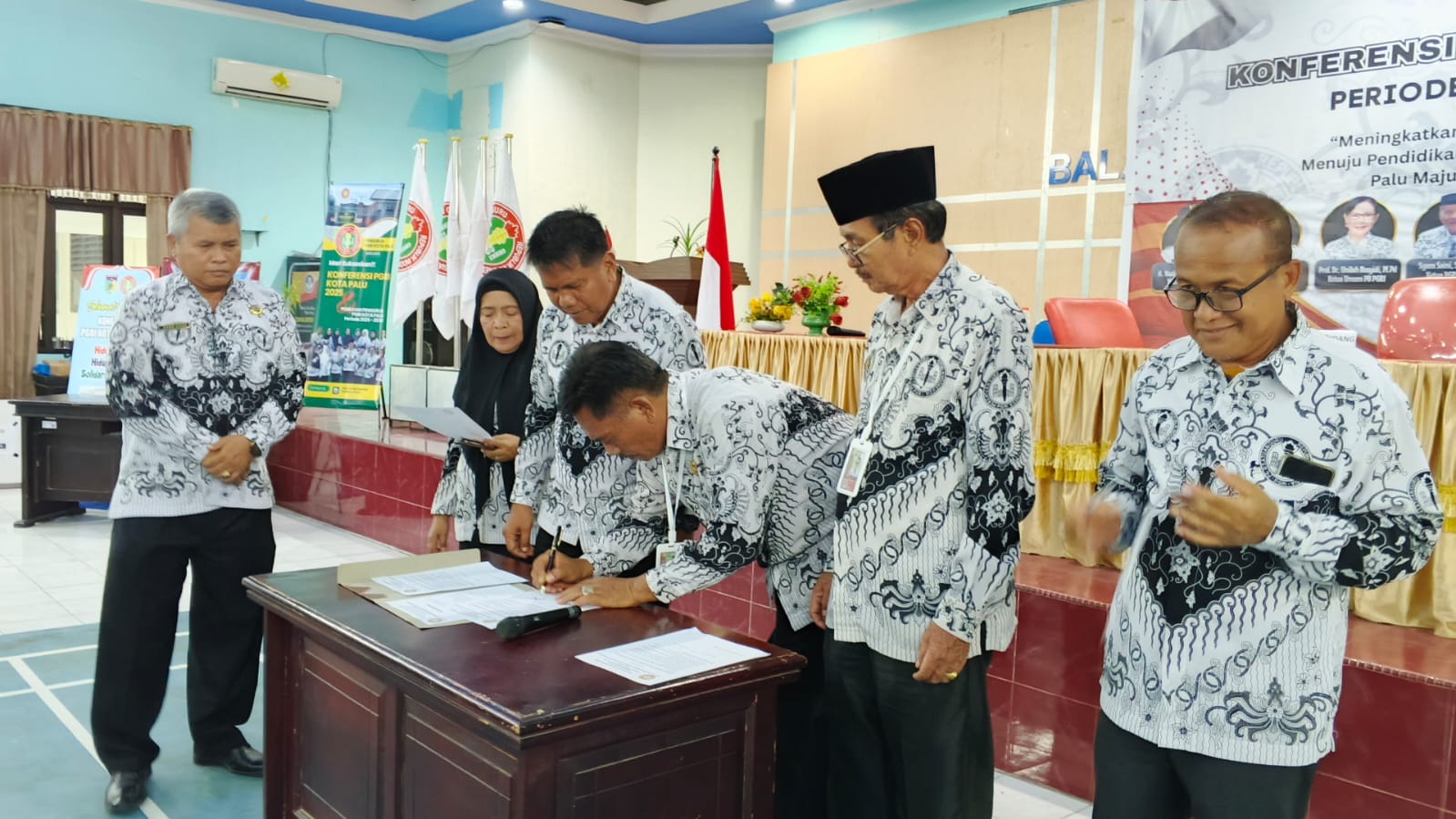 Ketua PGRI Kota Palu, Eddy Siswanto, menandatangani nota kesepakatan sebagai ketua terpilih periode 2025-2030. FOTO: Mohammad Rizal/Filesulawesi.com