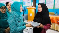 Sry Nirwanti Bahasoan, menyerahkan secara langsung paket Makan Bergizi Gratis (MBG) bagi anak-anak di Kabupaten Banggai Kepulauan. FOTO: IST