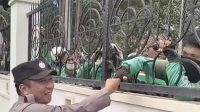 Anggota POLDA Sulteng, menyalami satu-satu pengemudi online dari balik pagar pembatas kantor DPRD Sulteng (aksi demonstrasi masih berlangsung).